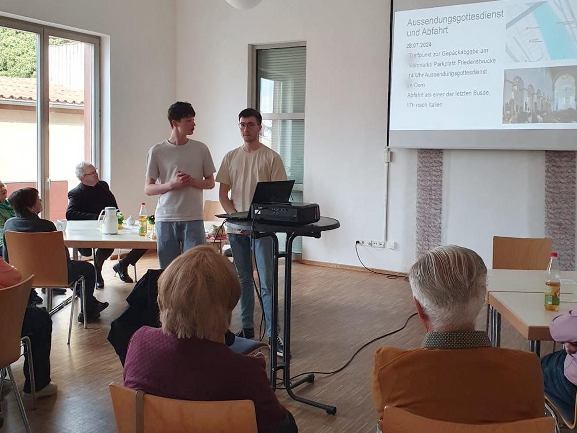 Zwei Jugendliche stehen in einer Runde und erzählen etwas.