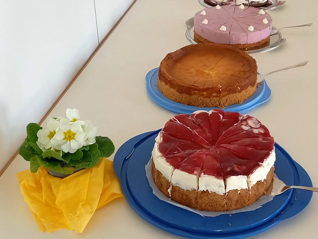 Ein Tisch mit verschiedenen Torten und eine Frühlingsblume.