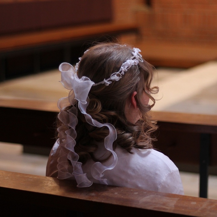 Kommunionkind in Kirchenbank