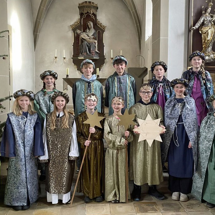 Eine Gruppe von Kindern hat die neuen Kleider an und schaut in die Kamera.