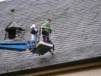 Zwei Männer arbeiten am Schieferdach der Wallfahrtskirche.