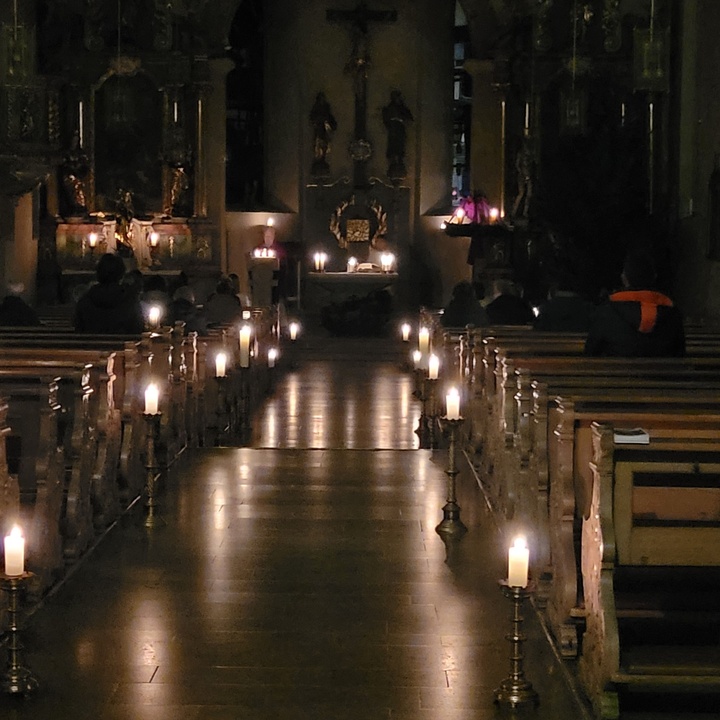 Blick von hinten auf den Altar, die Kirche ist nur mit Kerzen stimmungsvoll beleuchtet